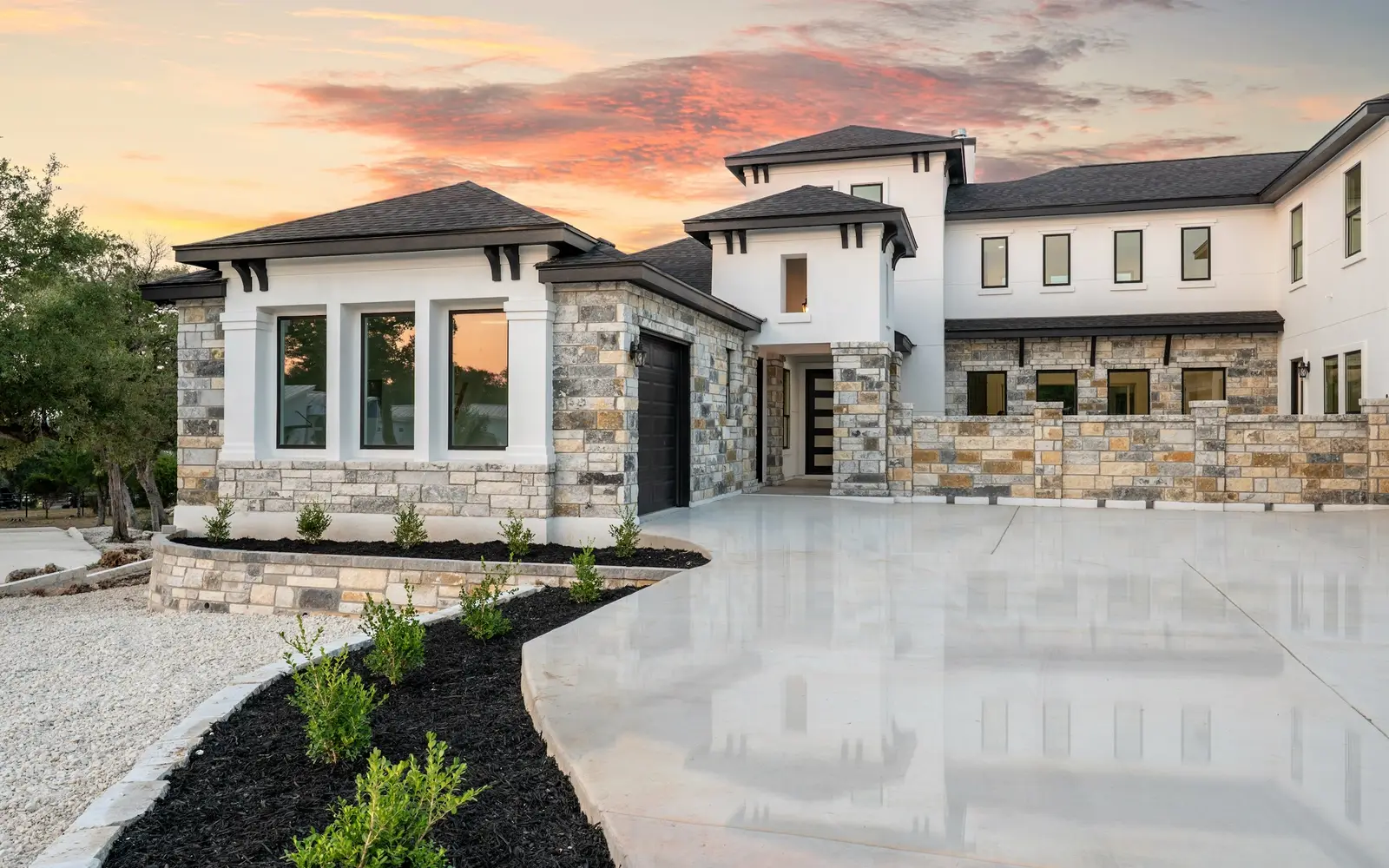 Luxury custom home with stone and stucco exterior at sunset